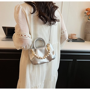 Sac nuage plissé argenté avec poignée en perles et chaîne porté par un mannequin