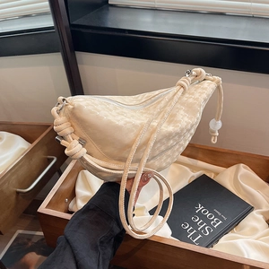 Sac bandoulière demi-lune crème avec texture gaufrée et bandoulière tressée élégante