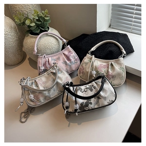 Close-up of four new Chinese style embroidered handbags with pearl charms and metal chains
