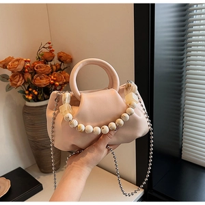 Détail du sac à main abricot plissé avec breloque en marbre et fine chaîne à billes argent