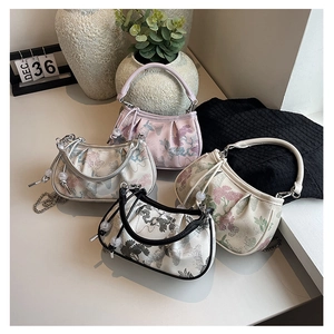 Detail of four embroidered handbags with floral patterns, round handles and chain straps