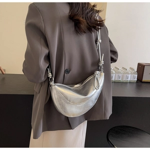 Silver metallic dumpling bag with knot detail worn by model from behind view