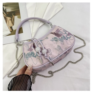 Close-up of lavender floral embroidery and pearl drawstring detail on handbag