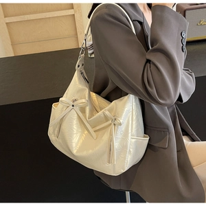 Detail of off-white Hobo bag with bow decoration and lychee texture for women