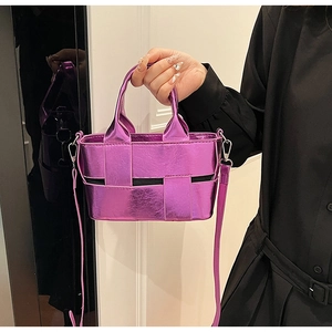 Detail of metallic purple woven handbag featuring leather texture and circular handle