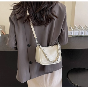 Détail de l'arrière d'un sac baguette blanc à motif crocodile et chaîne argent