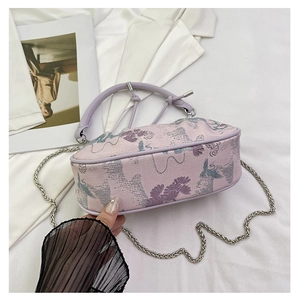 Close-up of lavender jacquard bag with crane embroidery and silver chain strap
