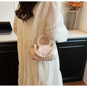 Détail du sac nuage plissé rose clair avec poignée en perles et bandoulière chaîne
