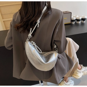 Detail of silver metallic dumpling bag with retro crinkled texture and knotted strap design