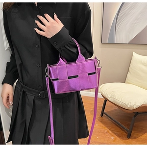 Detail of metallic purple woven handbag featuring high-gloss texture and crossbody strap