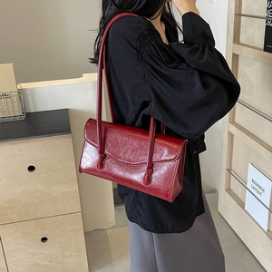 Fashionable dark red oily leather baguette bag with long straps for stylish women
