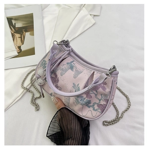 Close-up of pink floral jacquard embroidery on a semi-circle bag with silver chain