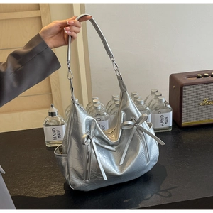 Close-up of silver lychee texture bucket bag with bow detail and metallic finish
