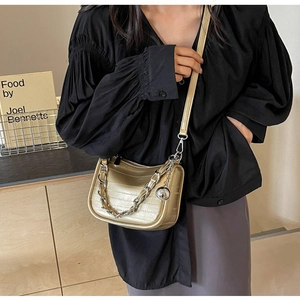 Détail du mini sac carré or champagne avec grosse chaîne argentée et pendentif boule