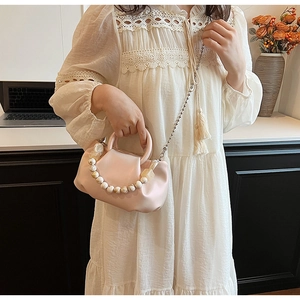 Détail du sac nuage plissé rose avec une poignée perlée unique à texture marbrée