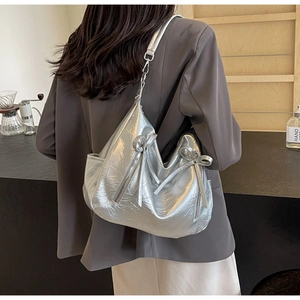 Close-up of a silver bucket bag with pleated texture and metallic finish details