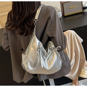 Detail of silver metallic bucket bag with bow accent and vintage wrinkled texture
