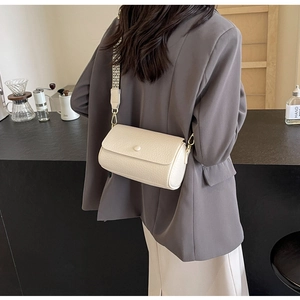 Detail of off-white lychee leather crossbody bag with geometric wide strap and gold hardware