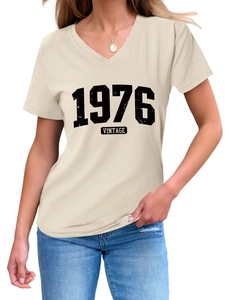 Close-up of distressed 1976 Vintage print on beige V-neck short sleeve t-shirt