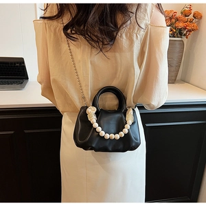 Détail du sac plissé noir avec poignée en perles crème et chaîne à billes dorée