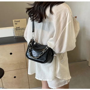 Sac bandoulière noir brillant avec chaîne argentée et charm boule en métal