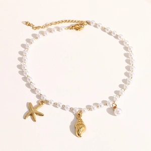 Detail of ocean-themed pearl anklet featuring gold starfish and seashell metal charms