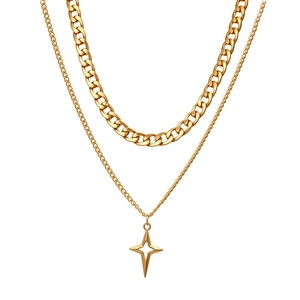 Detail of layered gold necklaces with curb chain and cutout star pendant charm