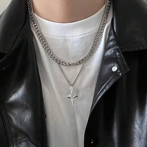 Detail of layered stainless steel chains with a hollow star pendant on a model