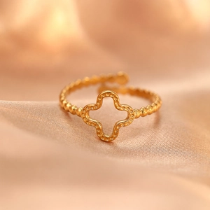 Adjustable golden hollow four-leaf clover ring with beaded band on champagne silk