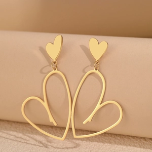 Vue macro de boucles d'oreilles pendantes coeur évidé plaqué or avec finition polie