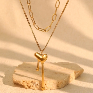 Detail of 18k gold plated double layer necklace with fluid lava heart pendant on stone