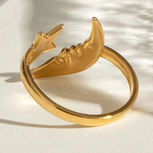 Macro shot of gold crescent moon and star adjustable ring with vintage engraving detail