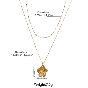 Détail du collier double rang doré avec pendentif fleur et spécifications de taille