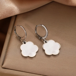 Fashionable shell flower drop earrings with silver stainless steel hoops on a jewelry box