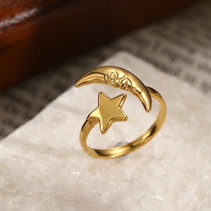Close-up of vintage gold sun and moon adjustable ring on marble with antique paper