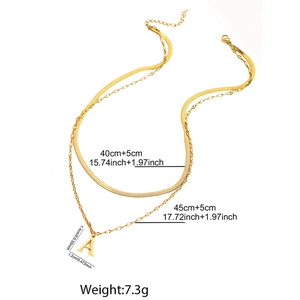 Detail of layered gold stainless steel snake chain and A-letter pendant necklace