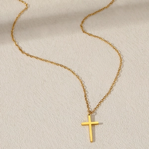 Collana con ciondolo a croce minimalista in acciaio inossidabile dorato da donna su bianco