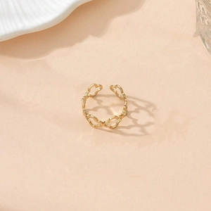 Close-up of golden hollow clover pattern ring with an adjustable open-end design
