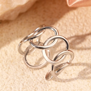 Macro shot of silver hollow rings interlaced design on textured silk fabric background
