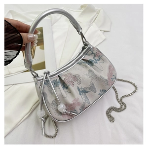 Detailed close-up of oriental flower and crane embroidery on a beige silk handbag