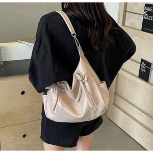 Detail of lychee textured bucket bag featuring decorative bow and silver hardware