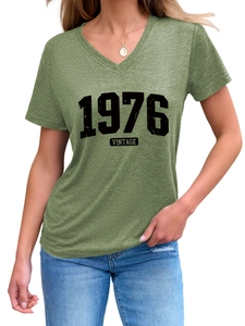 Close-up of V-neck cotton T-shirt featuring vintage 1976 black graphic print in grass green