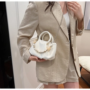 Détail d'un sac nuage blanc plissé avec perles marbrées et bandoulière chaîne