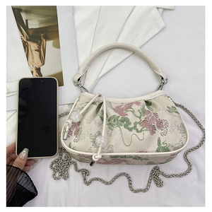 Detail of floral embroidery on off-white crossbody bag with elegant bead drawstring