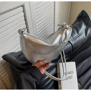 Detail of silver metallic crescent bag showing crinkled texture and industrial rope handle