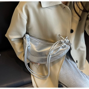 Detail of silver crescent bag with retro crinkled texture and knotted rope shoulder strap