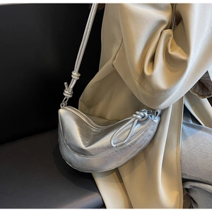 Detail of silver crescent bag with metallic crinkle leather and knotted strap accents