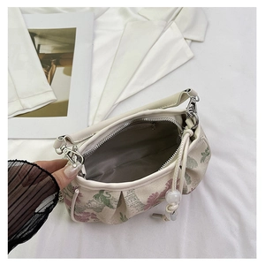 Detailed interior of vintage floral handbag featuring grey lining and zippered pocket