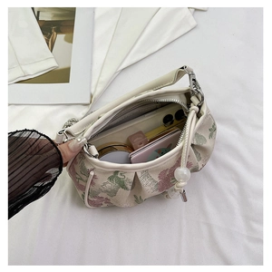 Detail view of embroidered crossbody bag with internal space for phone and makeup