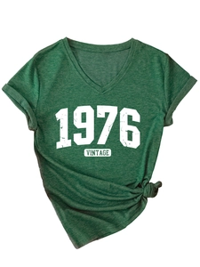 Close-up of a vintage V-neck dark green T-shirt with 1976 print and rolled sleeves